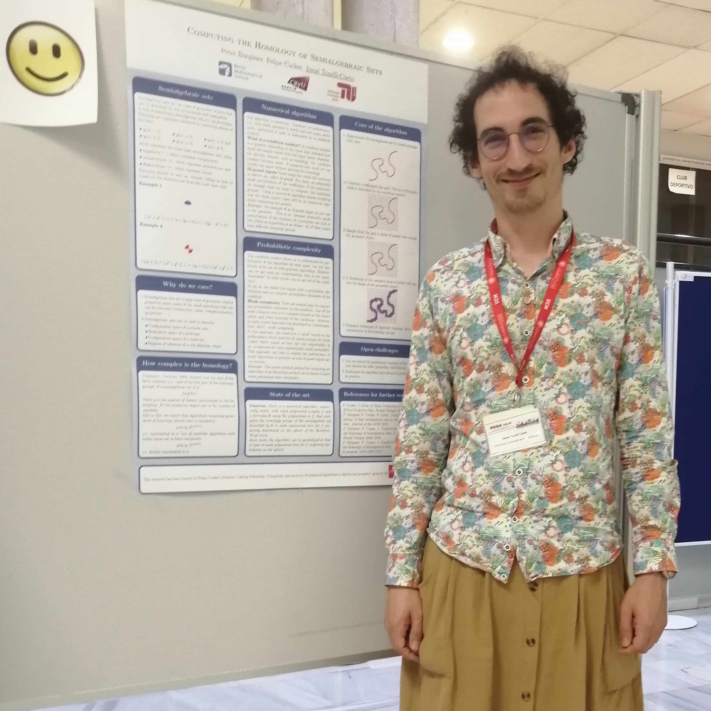 Josué Tonelli-Cueto in front of his poster at the MEGA 2019